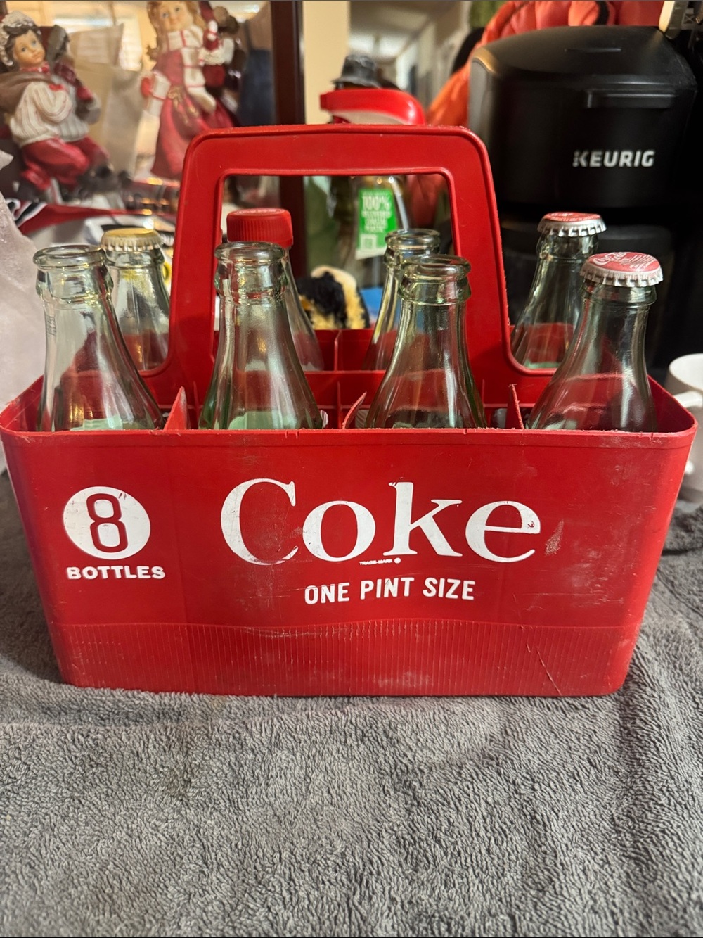 Coca-Cola Clear Glass Bottles with Red Label Accents and Red Plastic Carrier